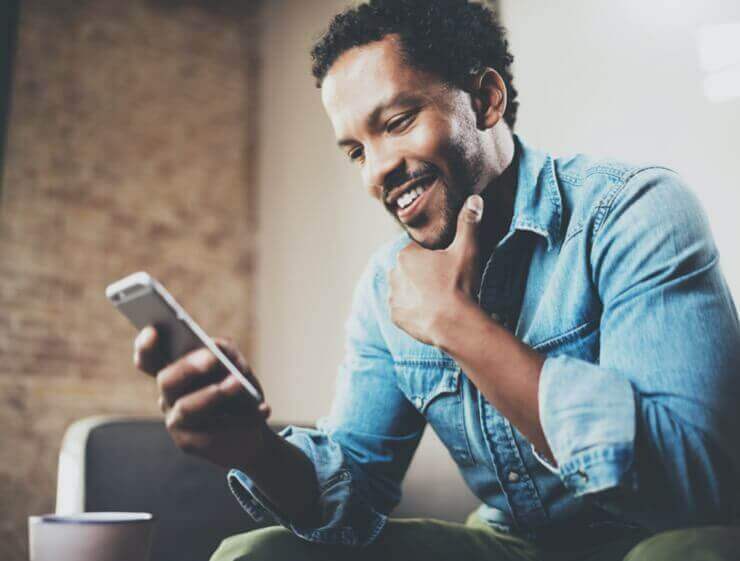 Man Sitting on a Couch Looking At His Phone